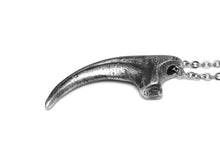 Antiqued Velociraptor claw pendant in pewter, showing the textured surface